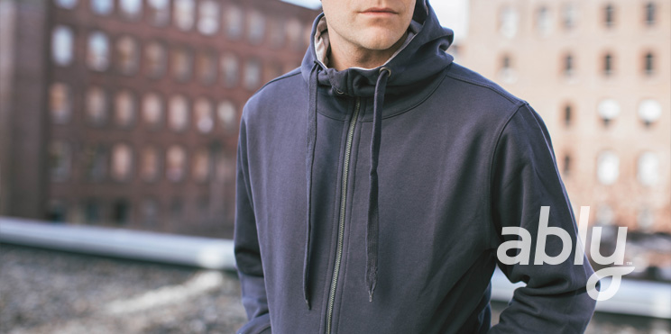 Model wearing a Filium-activated, navy hoodie made by Ably