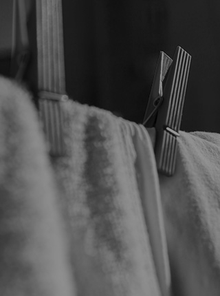 Black and white photo of a clothesline with linens [Mobile crop]