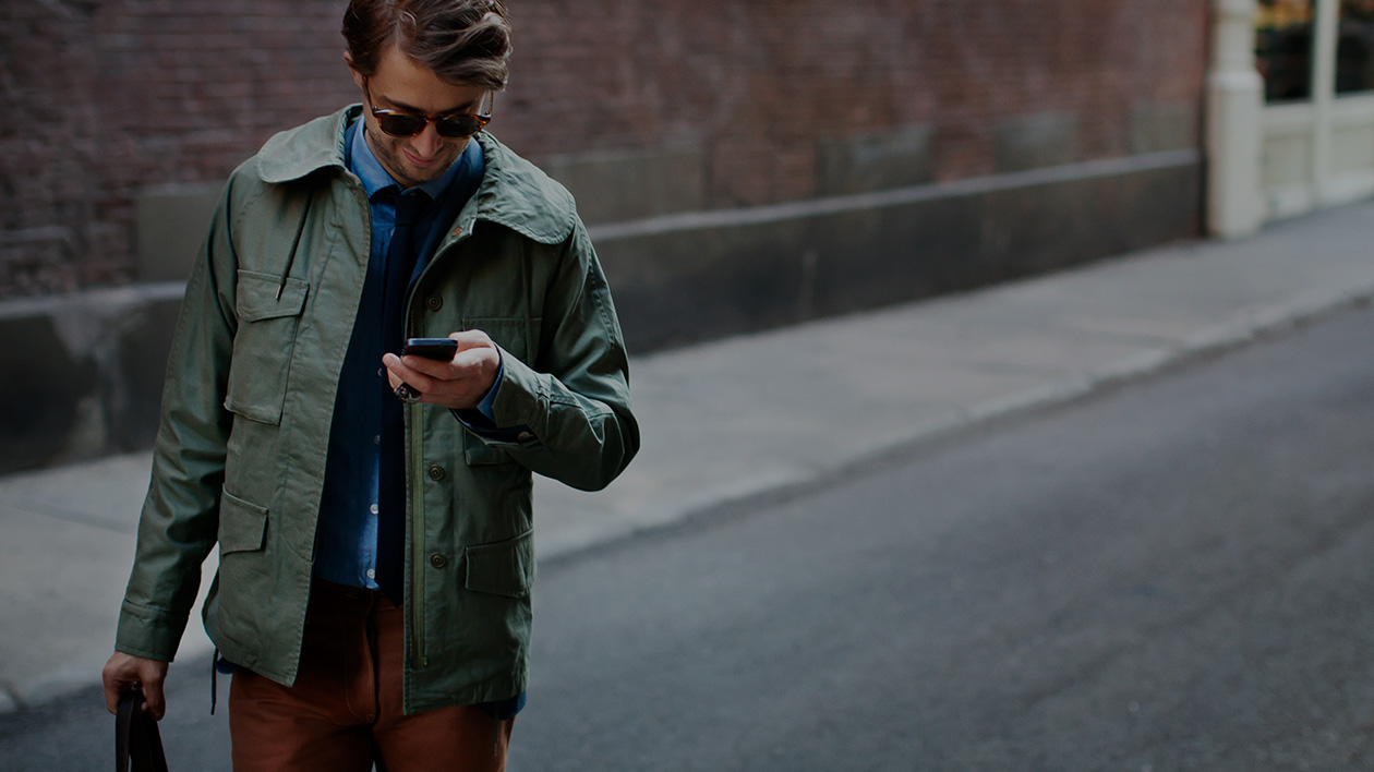 World traveler using a smartphone to navigate and wearing stylish Filium-activated apparel